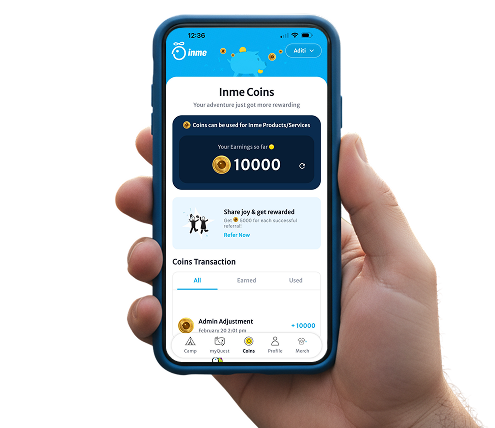 Hand holding smartphone showing INME Coins in the app